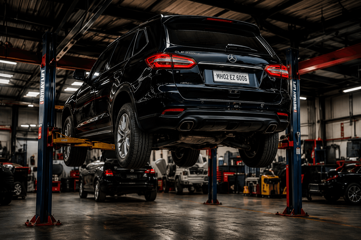 Black SUV raised on a two-post hoist, its underbody exposed for a safety inspection