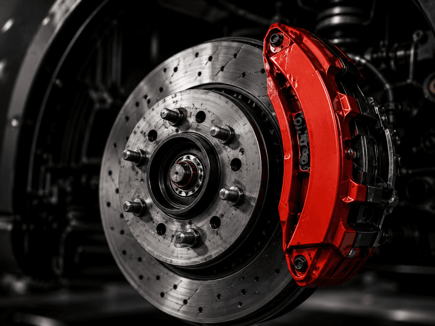 Drilled brake rotor and caliper exposed with the wheel removed for inspection